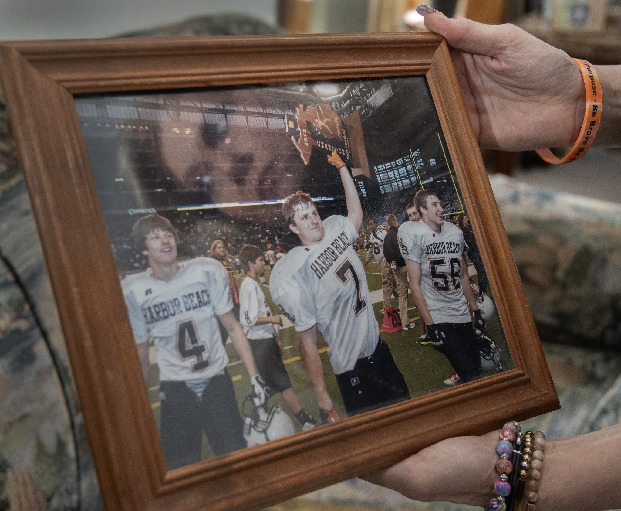 A framed photograph shows Derek Pfaff, #7, holding the state football trophy.