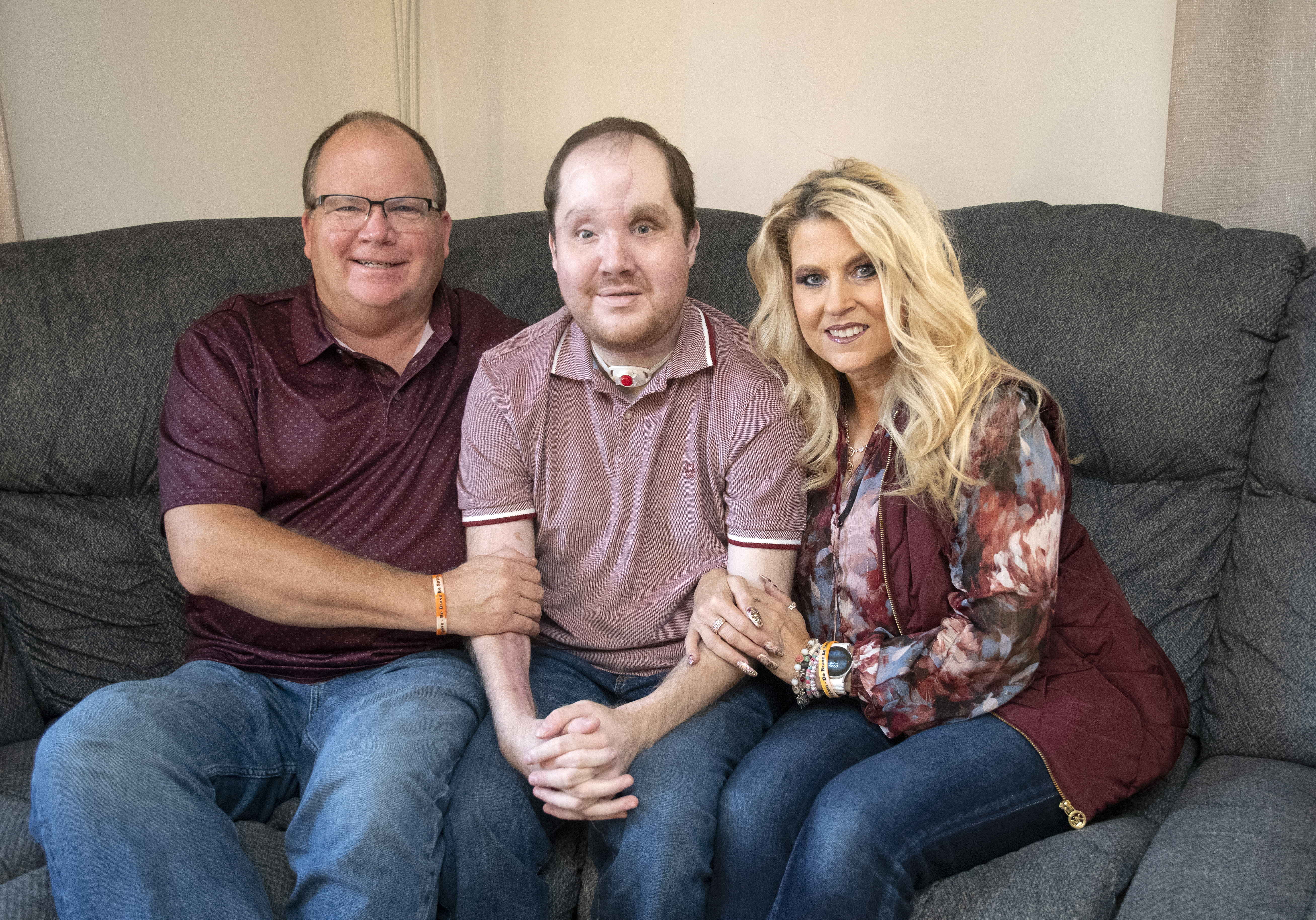 Derek sits on the couch with dad Jerry and mom Lisa